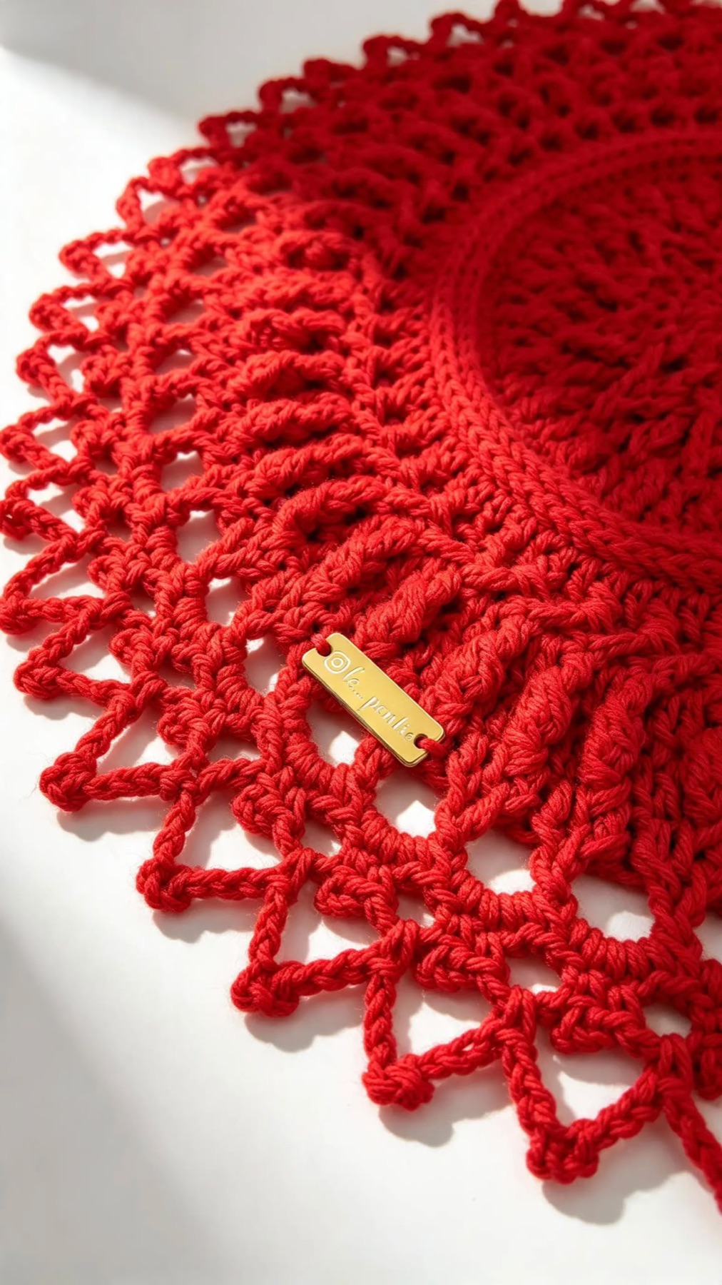 Sousplat de crochê vermelho com etiqueta dourada